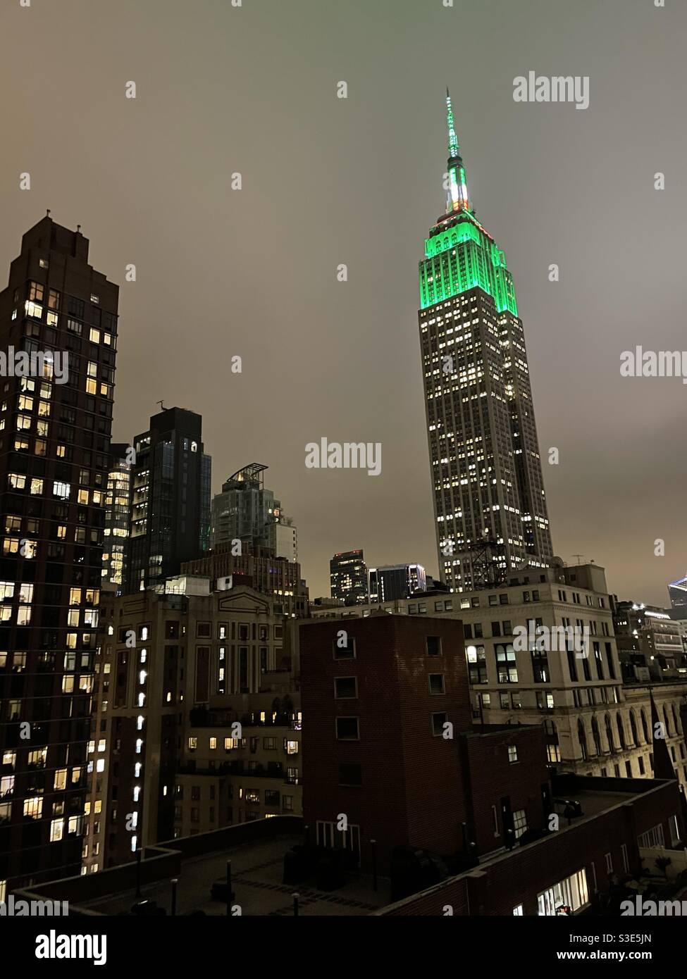 Empire state Building illuminato con luci verdi per St Patricks Day - Immagine stock catturata con smartphone