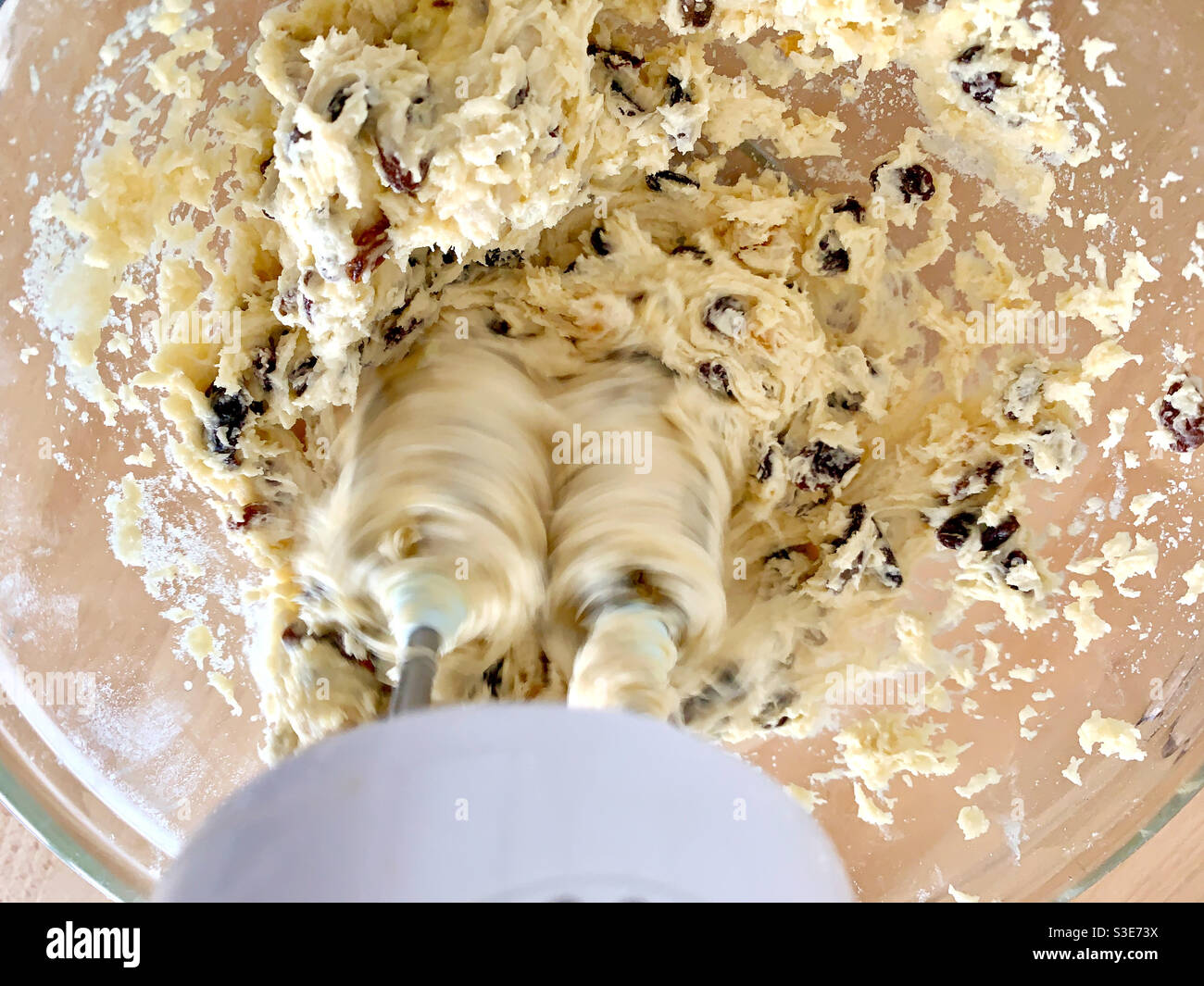 Miscela di torte di frutta fatte in casa che viene picchiata insieme con un miscelatore elettrico per le mani. - Immagine stock catturata con smartphone