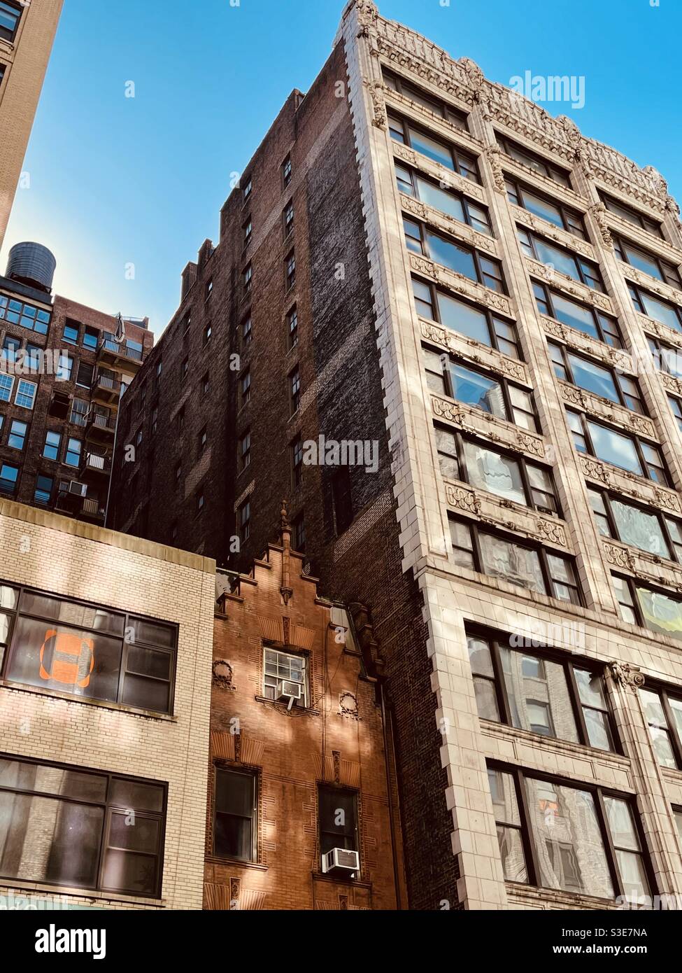 Piccolo e vecchio edificio incuneato tra alti edifici - Immagine stock catturata con smartphone