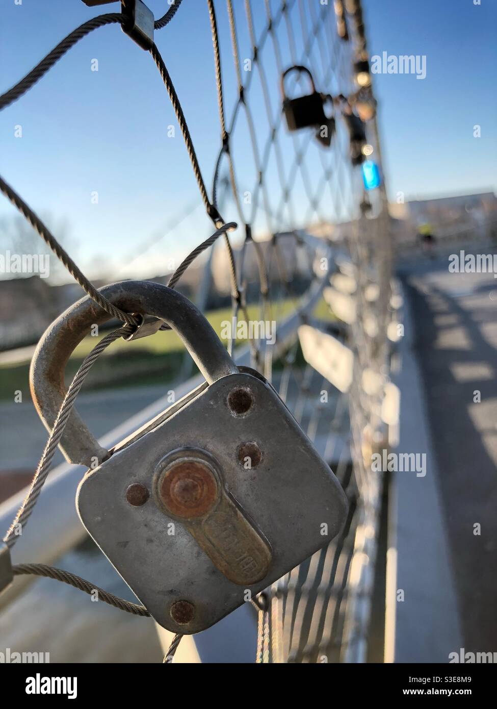 Lucchetti di amore appesi su una recinzione di filo Foto Stock