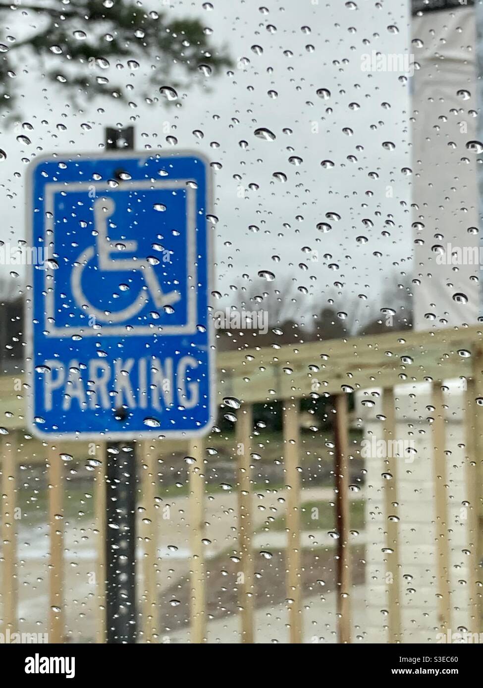 Cartello parcheggio per disabili sotto la pioggia Foto Stock