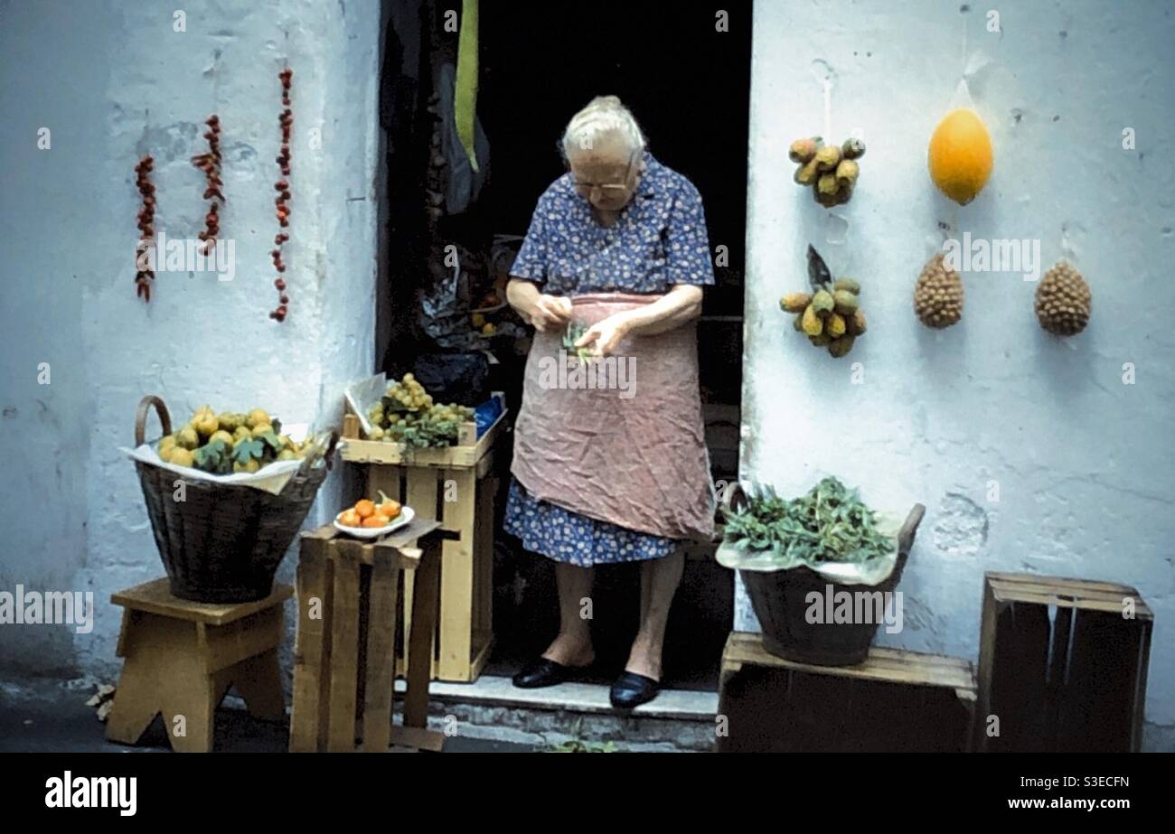 Donna italiana che vende verdure dal suo negozio ad Amalfi, Italia. - Immagine stock catturata con smartphone
