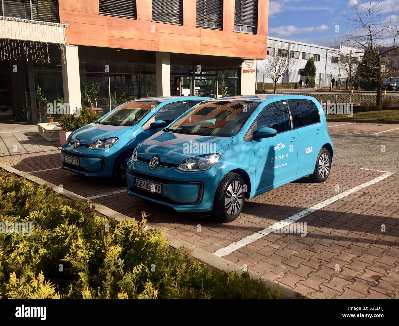 Due auto elettriche Volkswagen e-up per il programma di condivisione delle auto Spark parcheggiate nel Sofia Business Park di Sofia, Bulgaria, Europa orientale, UE - Immagine stock catturata con smartphone