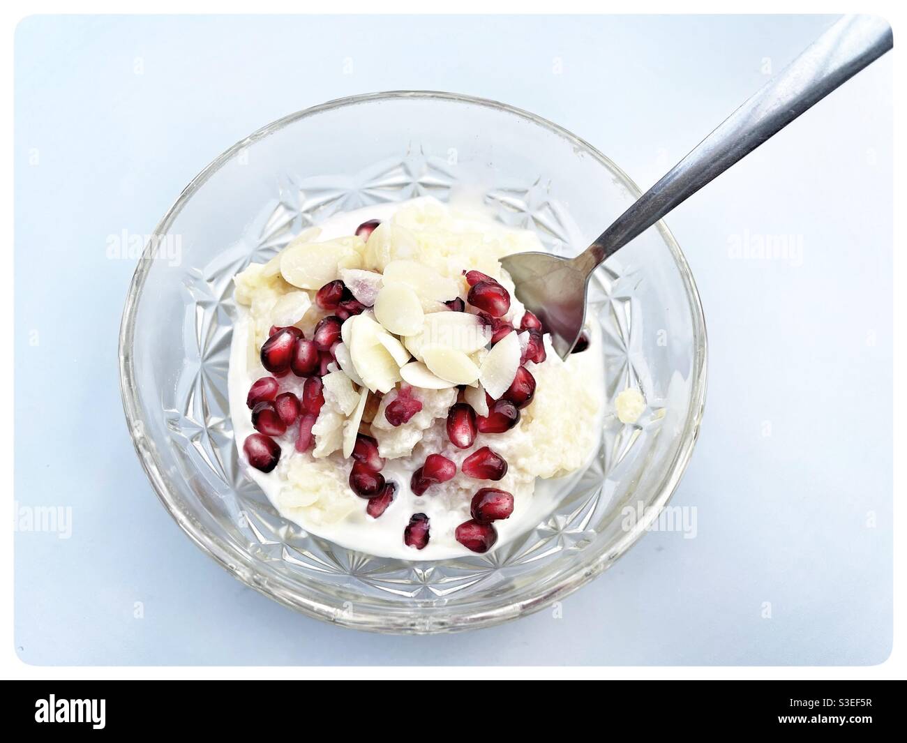 Budino di riso con semi di melograno e mandorle in fiocchi - Immagine stock catturata con smartphone