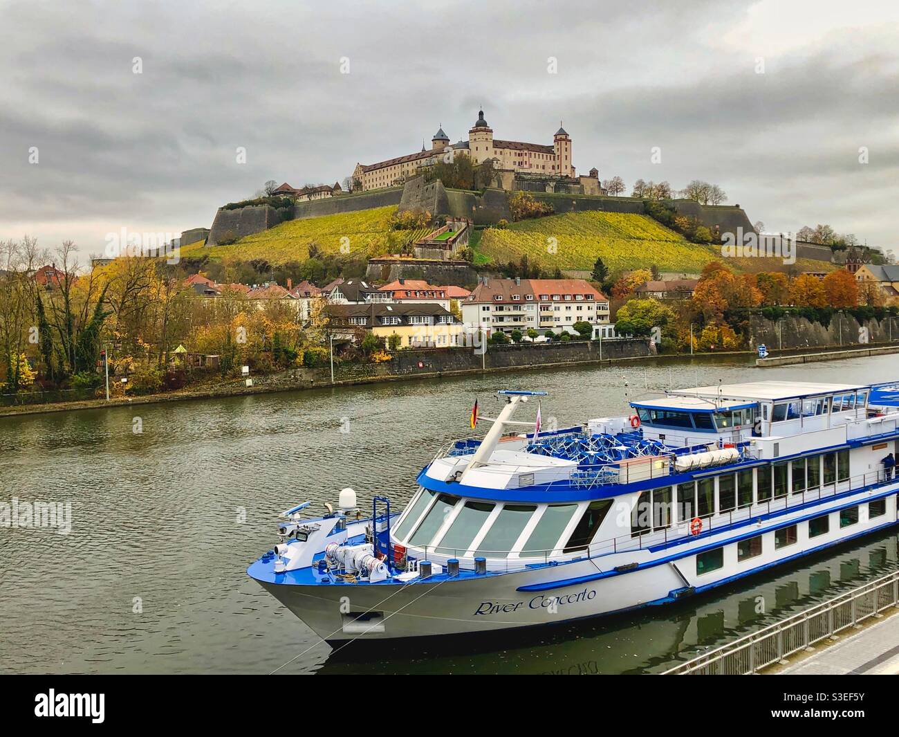 Vista sulla fortezza di Marienberg circondata da vigneti e sul fiume meno con una barca a Würzburg, Germania. - Immagine stock catturata con smartphone