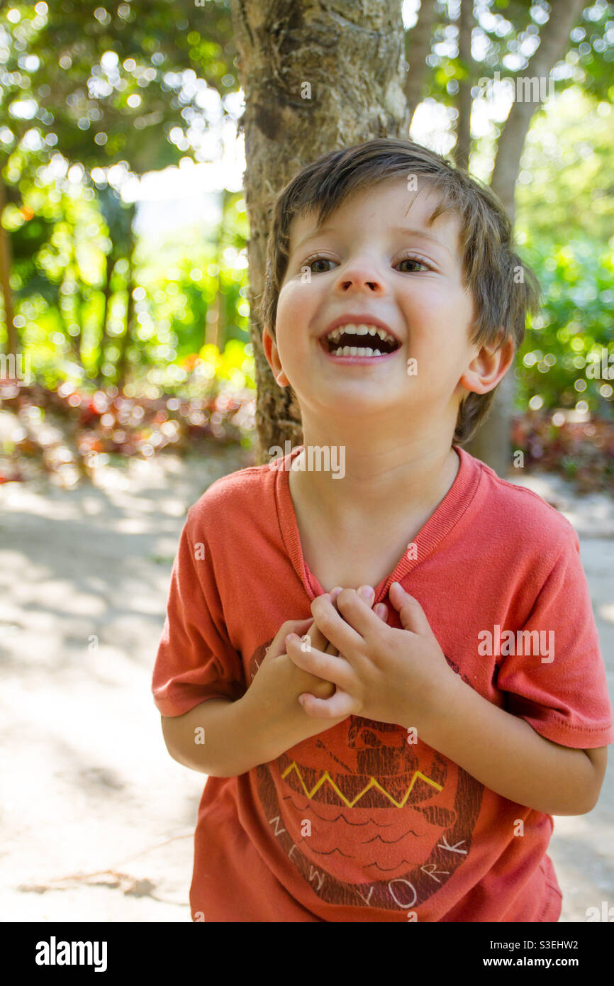Young Boy ridendo forte in ambiente naturale Foto Stock