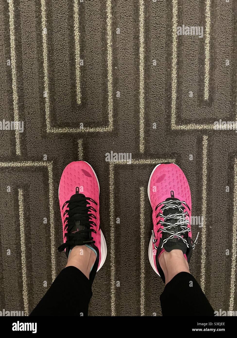 Paio di scarpe atletiche Nike rosa caldo da donna con abbinamenti  discordanti lacci su un tappeto Foto stock - Alamy
