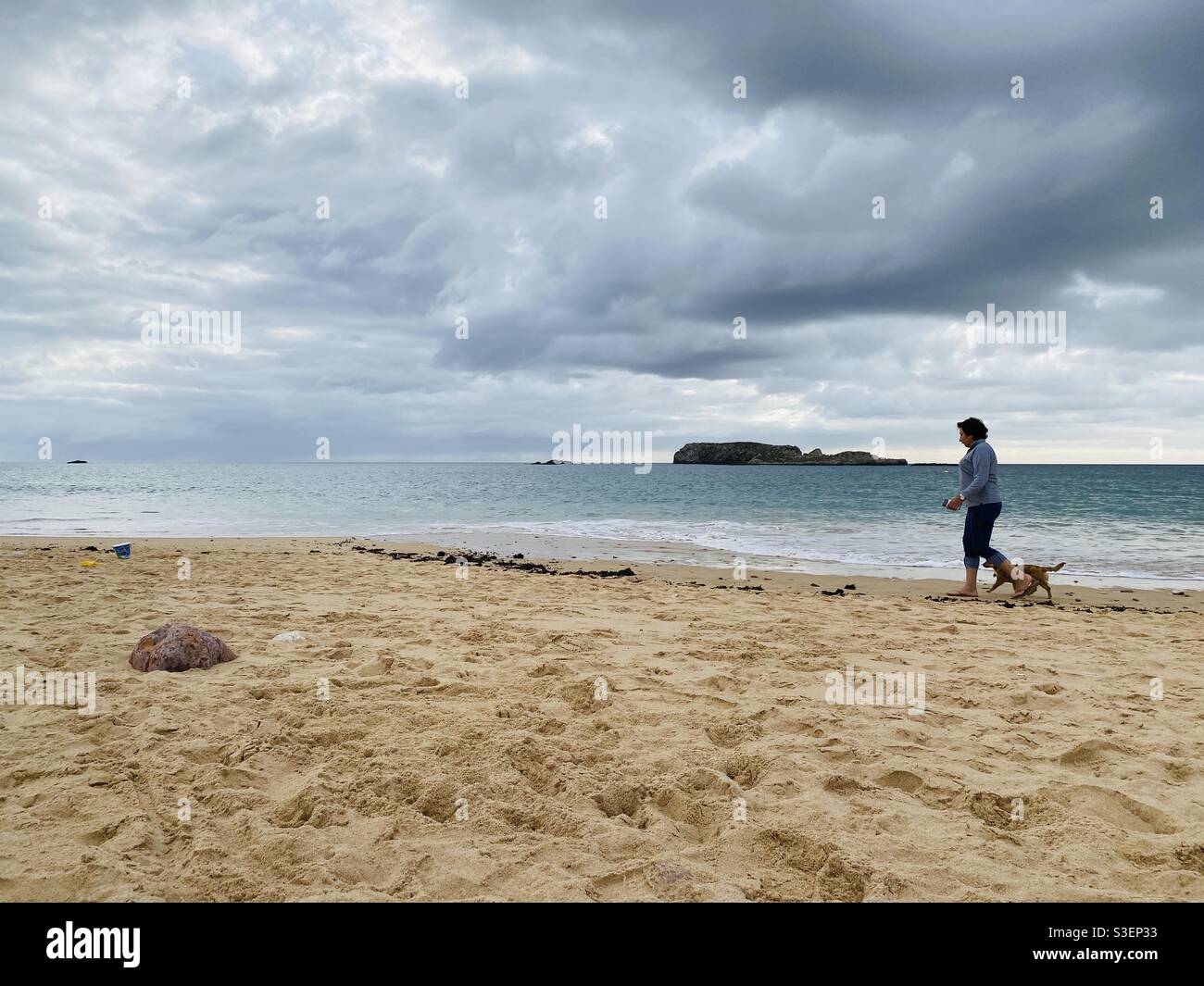 Signora che cammina il suo cane sulla spiaggia in inverno - Immagine stock catturata con smartphone