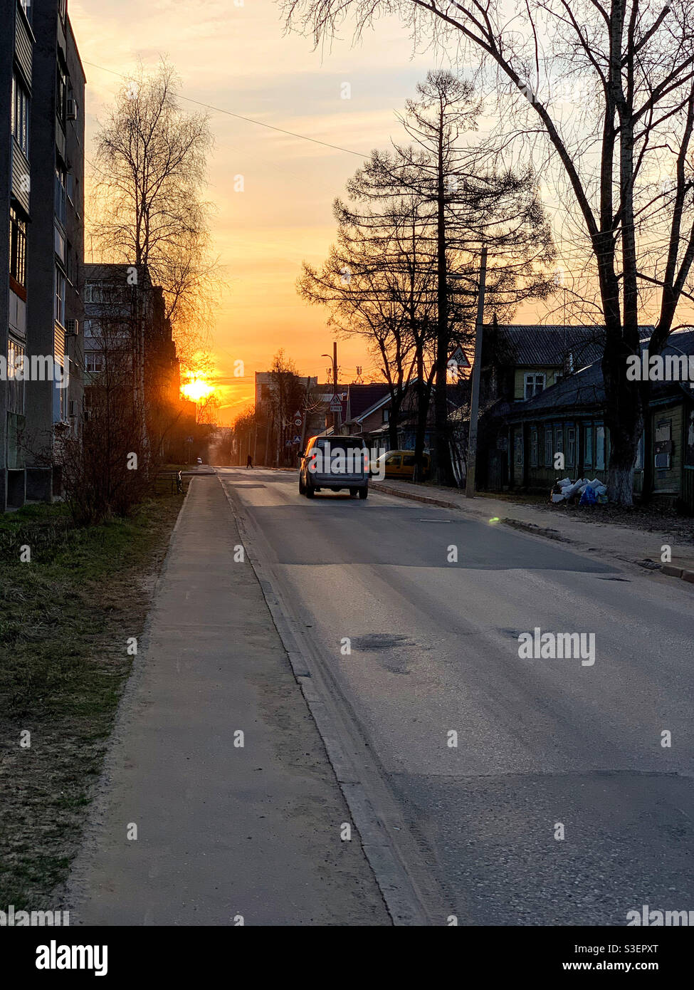 La macchina percorre la strada verso il sole che sale - Immagine stock catturata con smartphone