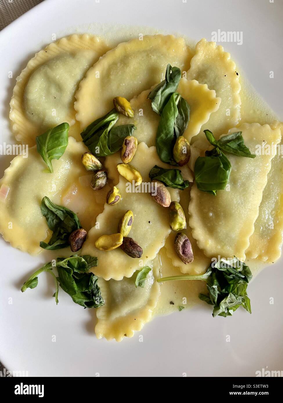 La coscia piatta di un pasto di ravioli condita con fresco basilico e pistacchi Foto Stock