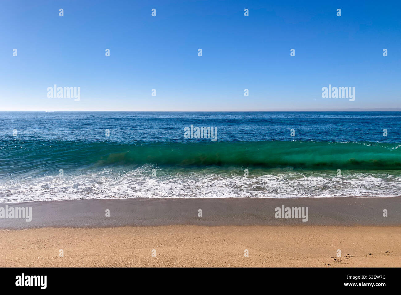 Turchesi onde oceaniche in procinto di rompere sulla spiaggia di sabbia in una soleggiata giornata in California. - Immagine stock catturata con smartphone