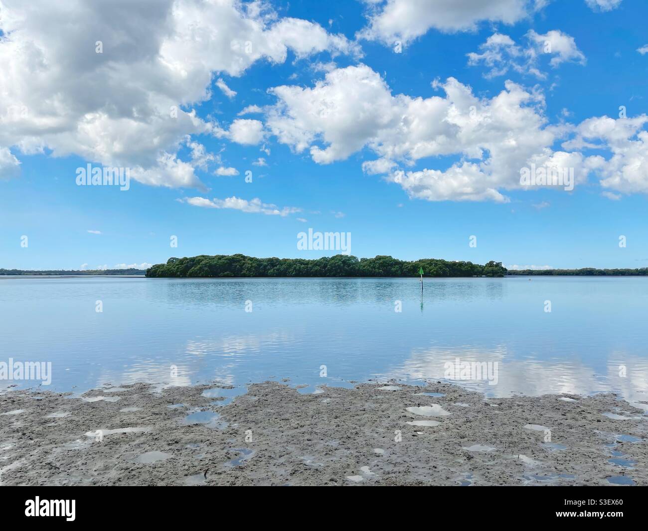 Vista panoramica ad ampio angolo dell'Isola di Little Goat con bassa marea con spettacolari nuvole in alto - Pumicestone Passage. Queensland, Australia Foto Stock