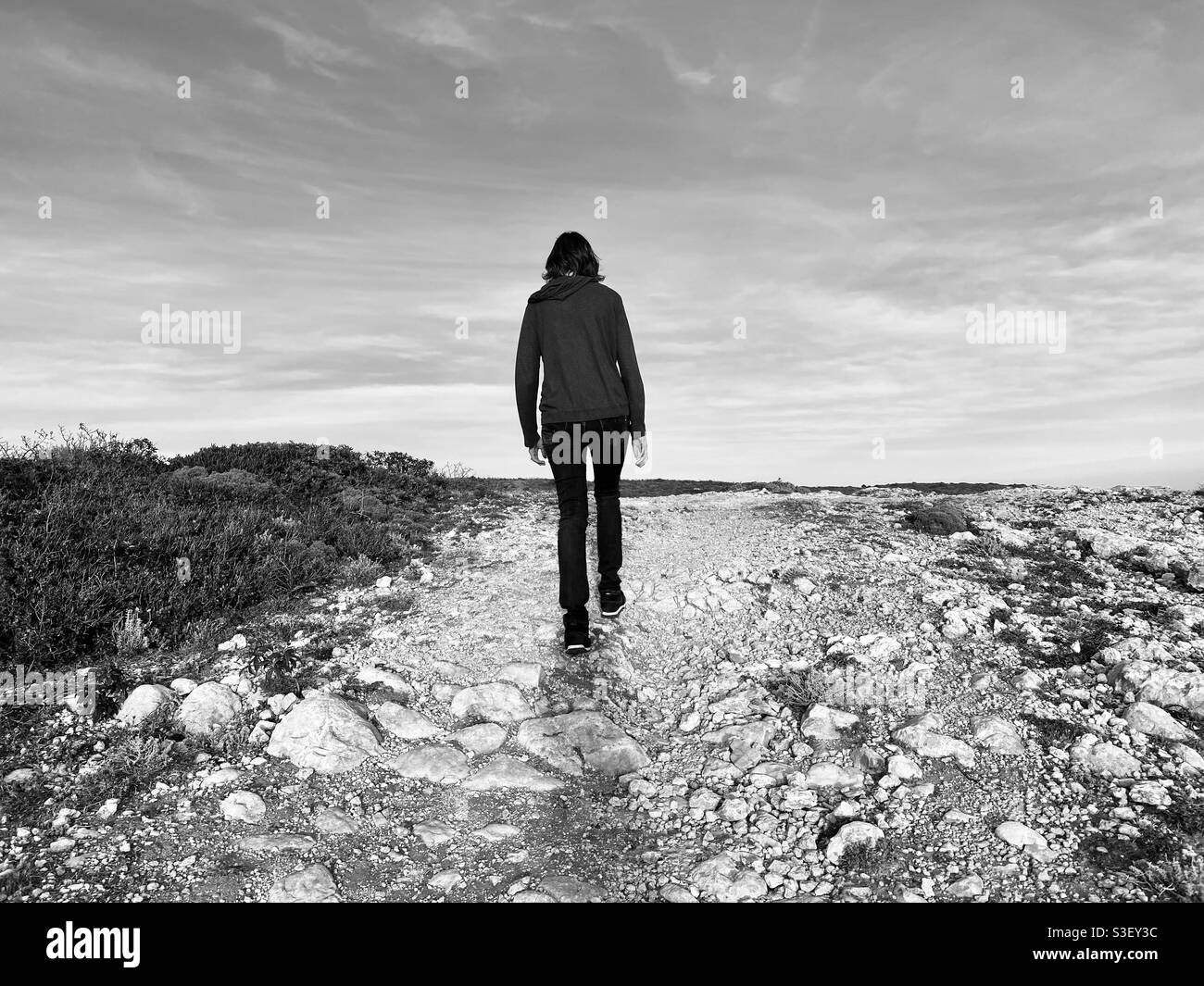 Vista posteriore della donna che cammina su un sentiero Stoney - Immagine stock catturata con smartphone Vista posteriore della donna che cammina su un sentiero Stoney - Immagine stock catturata con smartphone