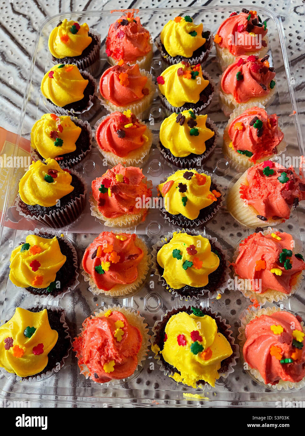 Un'allettante esposizione di mini cupcake ghiacciati con glassa colorata Foto Stock