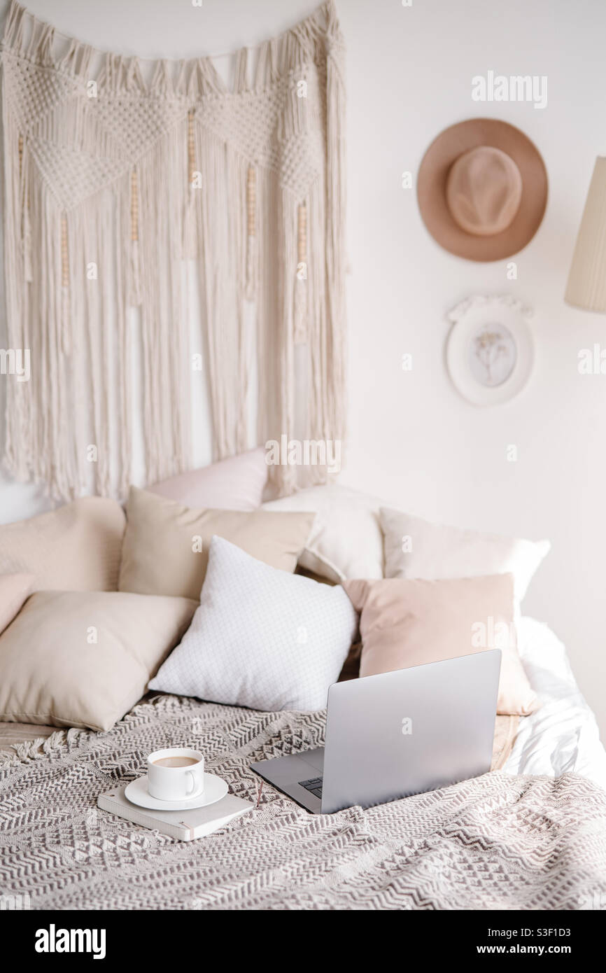 Lavoro elegante da casa con computer portatile e caffè tazza in colori beige Foto Stock