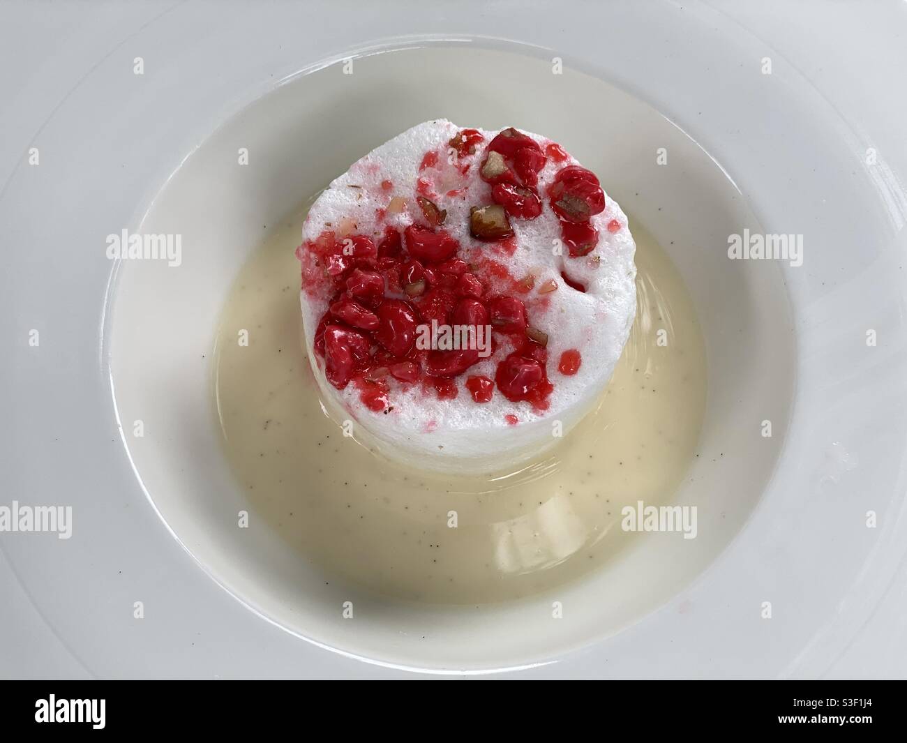 Isola galleggiante Île dessert flottante con mousse bianca all'uovo panna ricoperta di frutti rossi Foto Stock