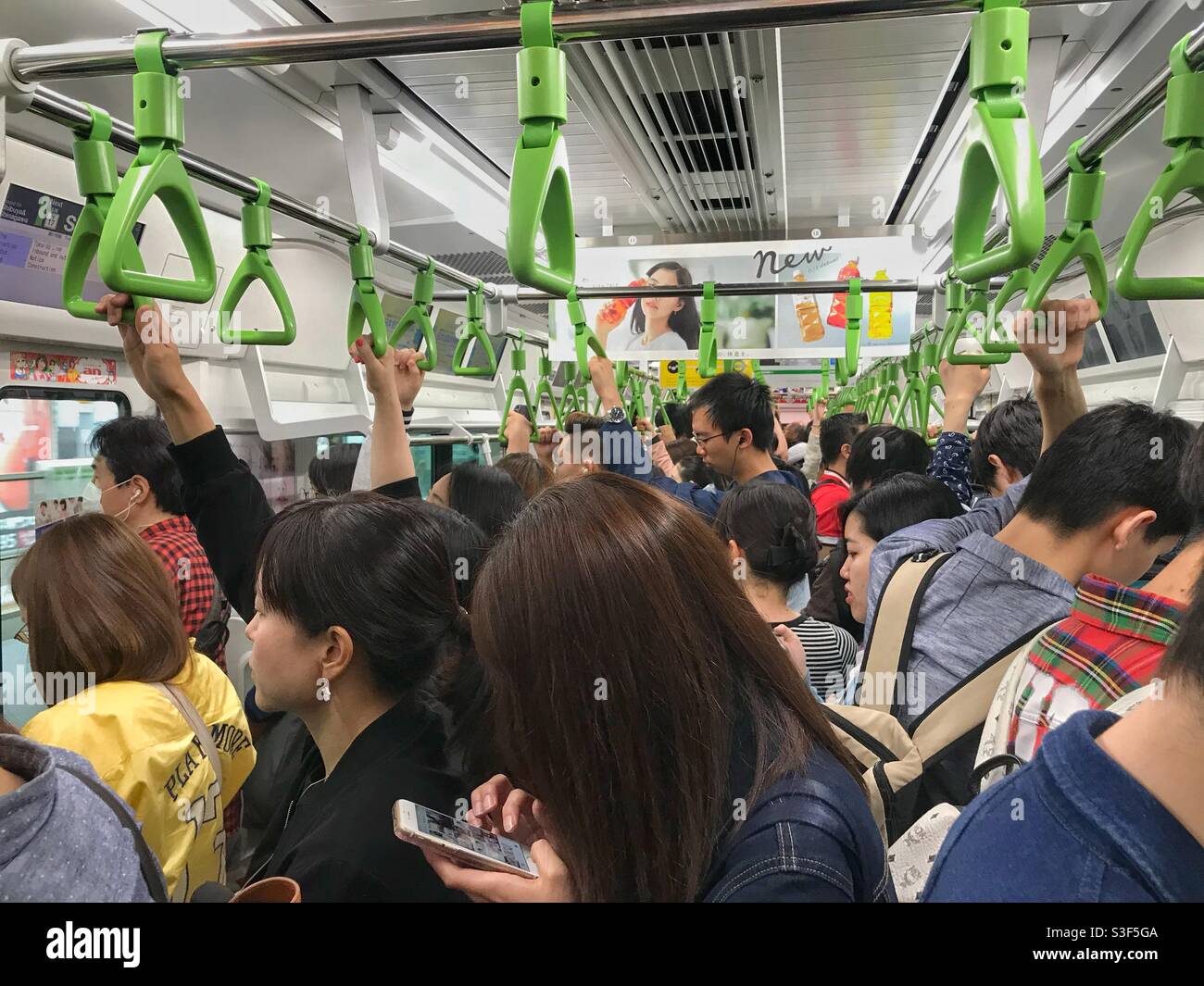 Affollata carrozza ferroviaria a Tokyo, Giappone - Immagine stock catturata con smartphone