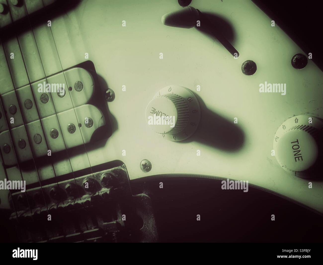 Immagine dettagliata dei quadranti del tono e del volume su un vecchio sconfiggi la vecchia chitarra elettrica - Immagine stock catturata con smartphone