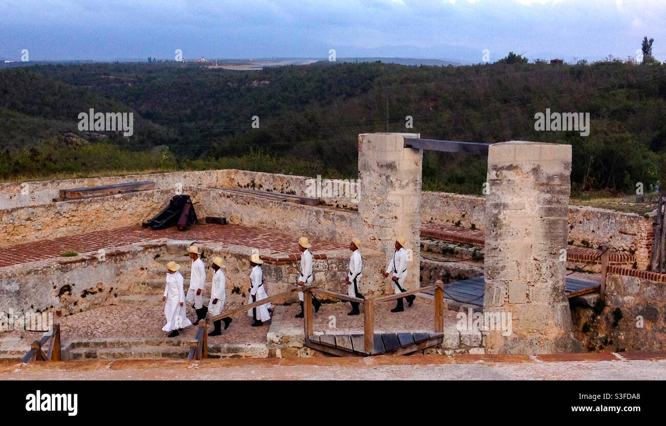 I giovani cadetti in uniforme entrano a Castillo de San Pedro de la Roca o al Castello Morro al crepuscolo per la mostra di sparo a pistola per i turisti, Santiago de Cuba, Cuba Foto Stock