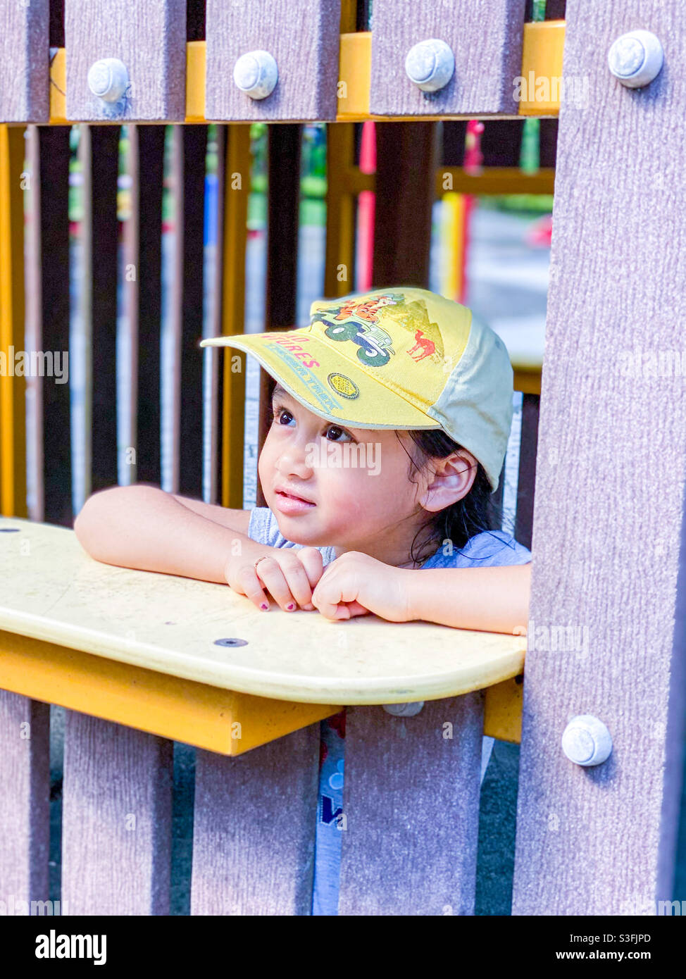 Bambina al parco giochi sognando via Foto Stock