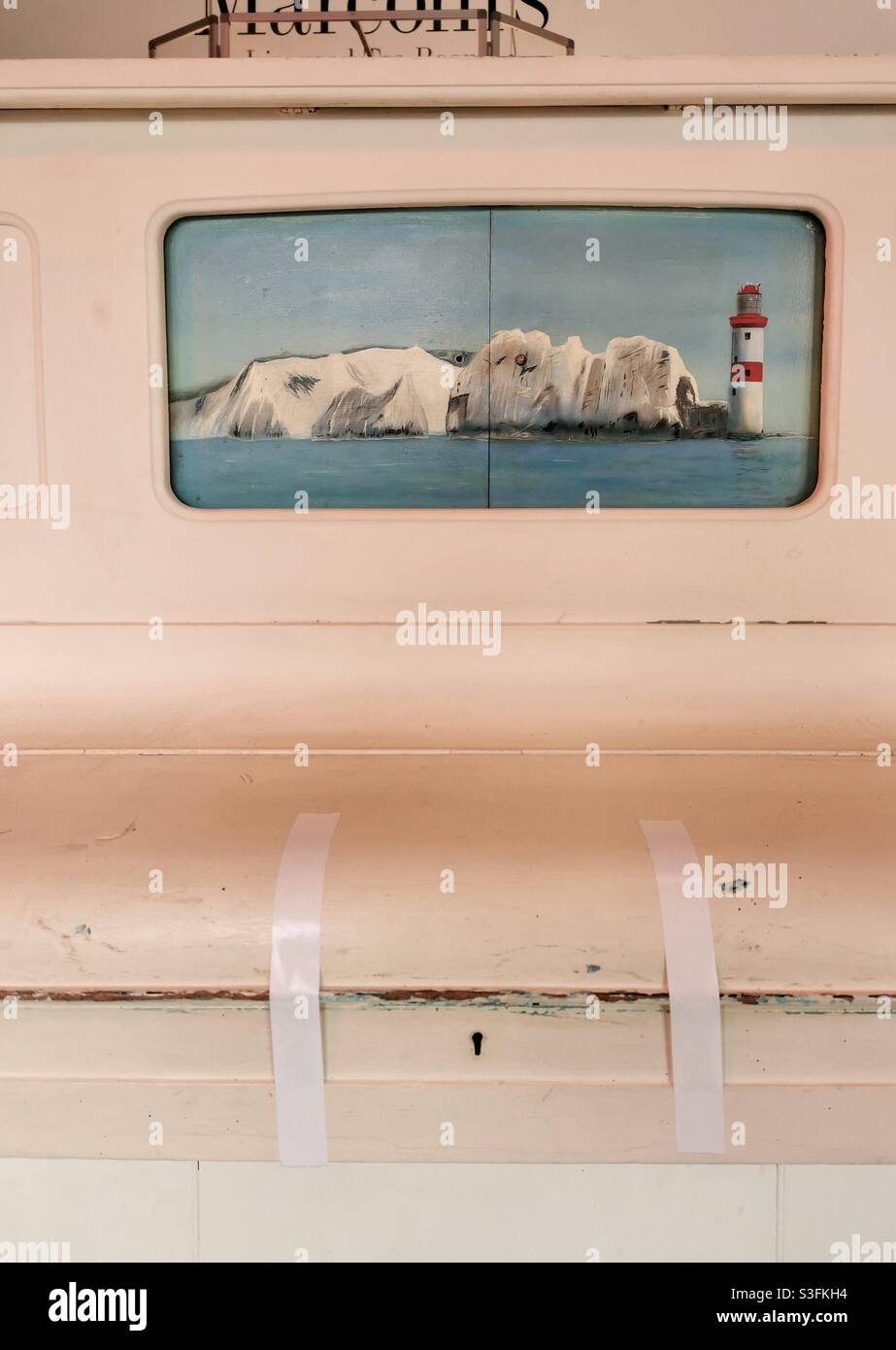 Pittura degli aghi e faro nell'isola di Wight su un vecchio pianoforte rosa Foto Stock