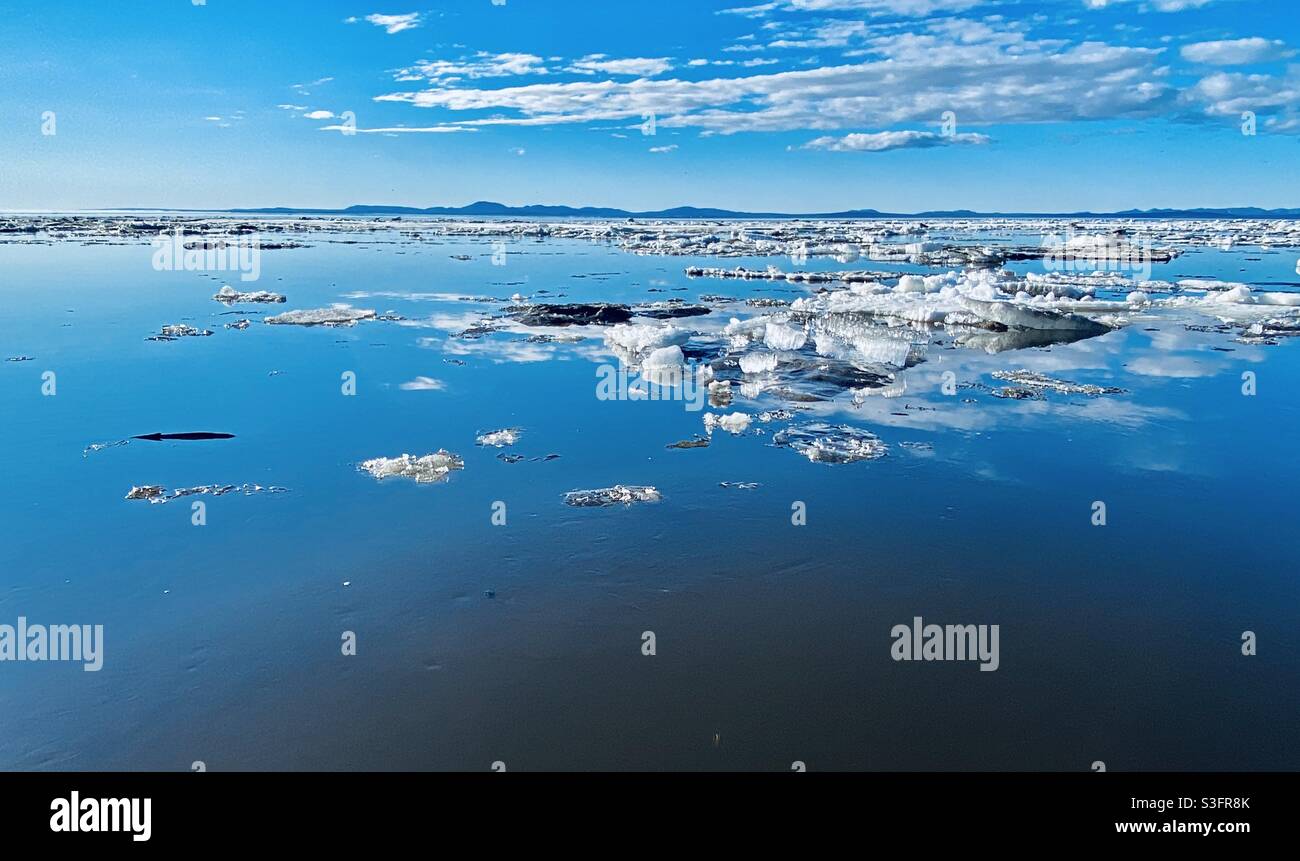 Il ghiaccio galleggia a Kotzebue Sound dall'annuale rottura primaverile del mare e del ghiaccio fluviale nell'Artico dell'Alaska. Kotzebue, Alaska, Stati Uniti (Cape Krusenstern National Monument area in background) Foto Stock