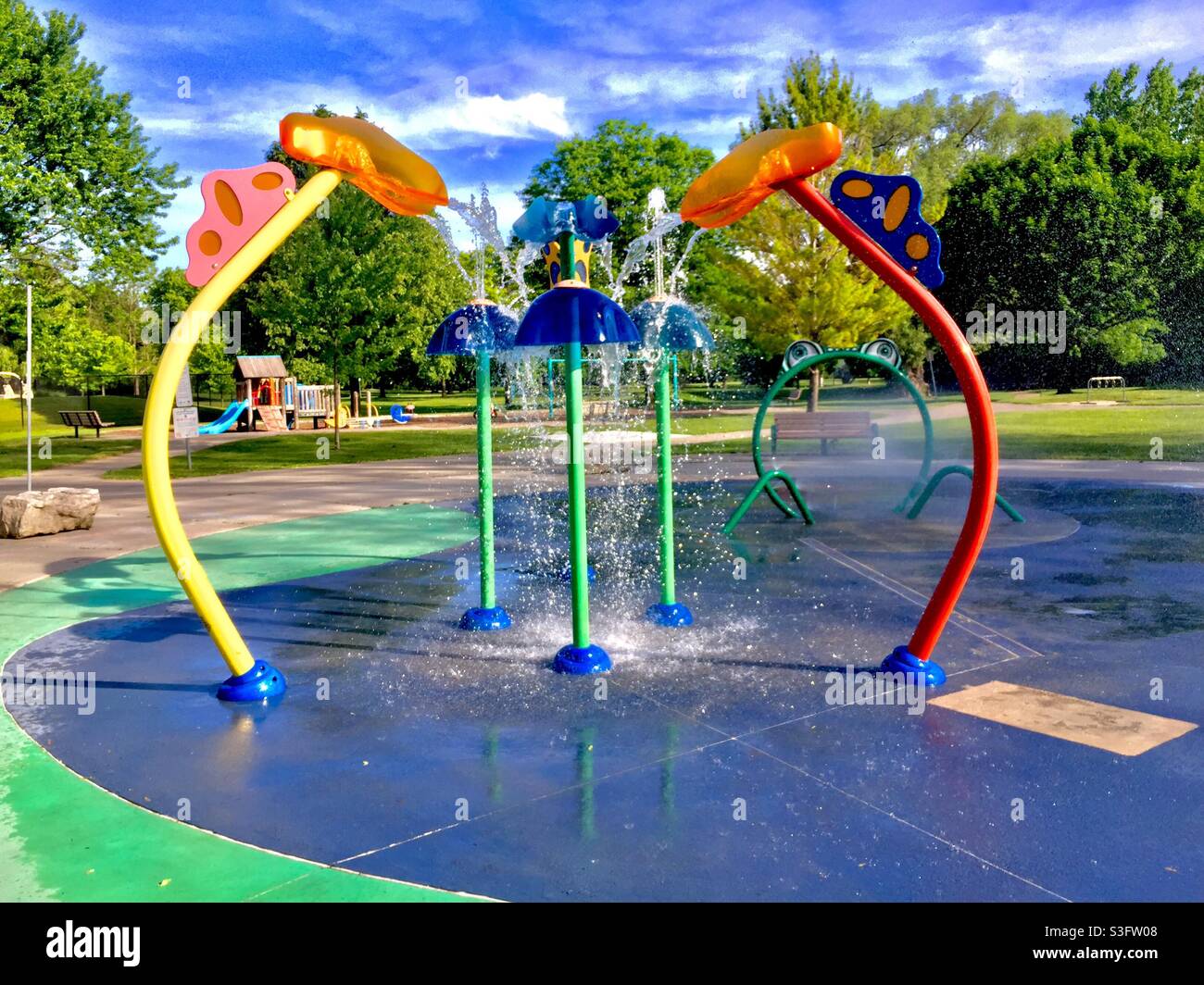 Paraspruzzi con fontane d'acqua, moderna zona fieristica in un parco, Ontario, Canada. Luogo popolare per rinfrescarsi e divertimento in primavera, estate e inizio autunno. - Immagine stock catturata con smartphone