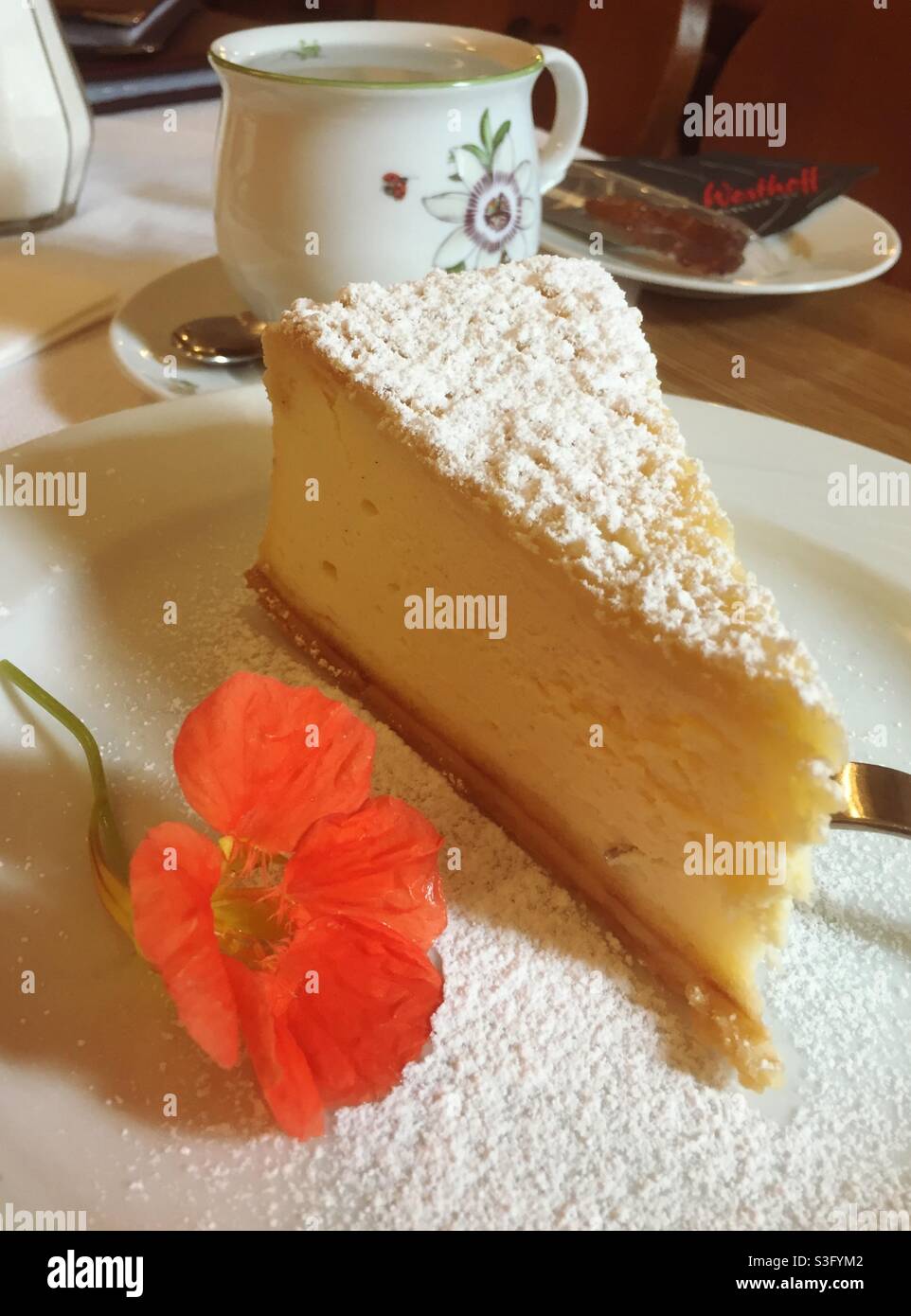 Un pezzo di cheesecake fresco con una tazza di caffè - Immagine stock catturata con smartphone