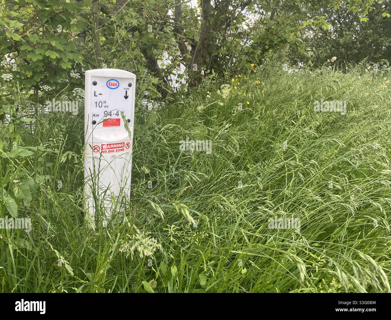 Punto di marcatura della linea di gas nel mezzo di una riva del fiume - Immagine stock catturata con smartphone