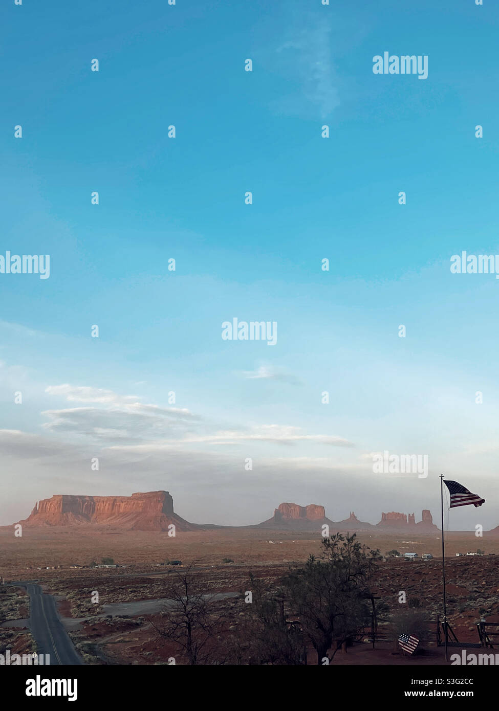 Tramonto al mattino presto sopra la Monument Valley e bandiera americana Foto Stock
