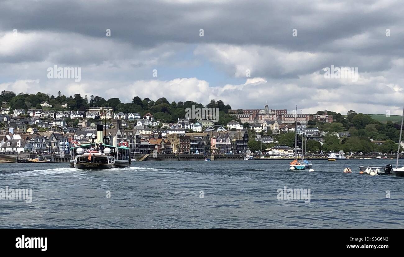 Pagaia Steamer Kingswear Castle in direzione di Dartmouth Town sul fiume Dart con la Britannia Royal Naval Collage sulla collina Foto Stock