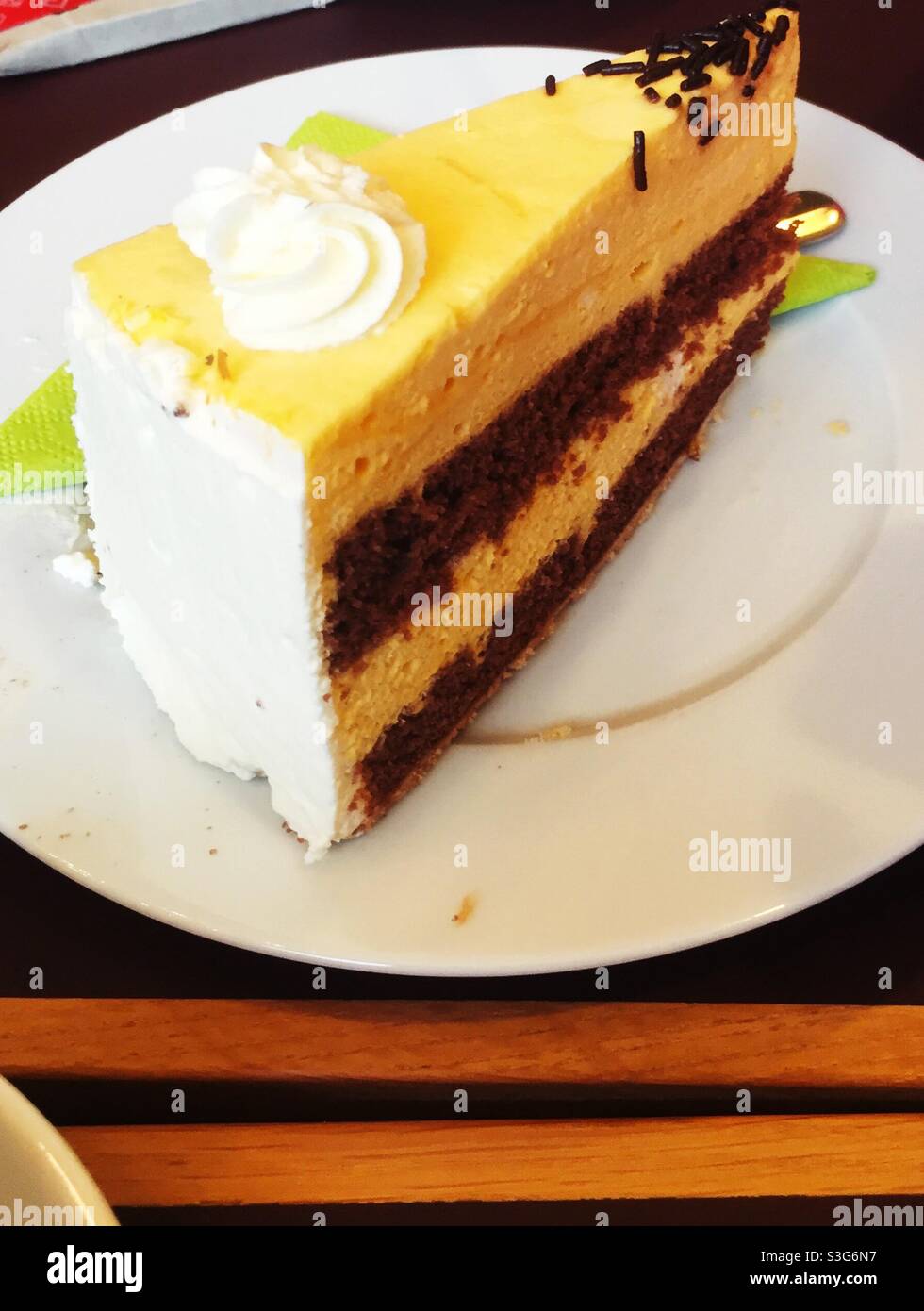 Yummy pezzo di una torta a strato di crema di mango - Immagine stock catturata con smartphone