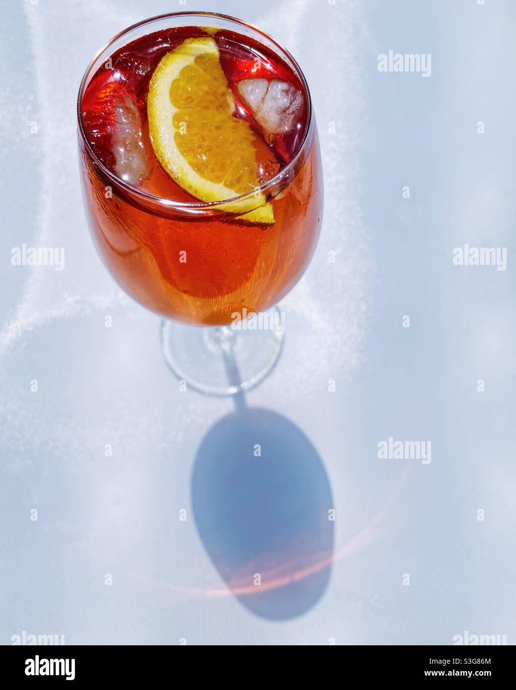 Aperol Spritz esterno su un tavolo bianco, dall'alto con l'ombra di vetro. Foto Stock
