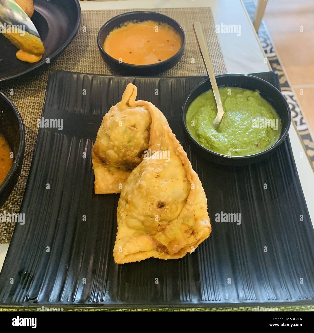 Samosa vegetariana con chutney verde. Foto Stock