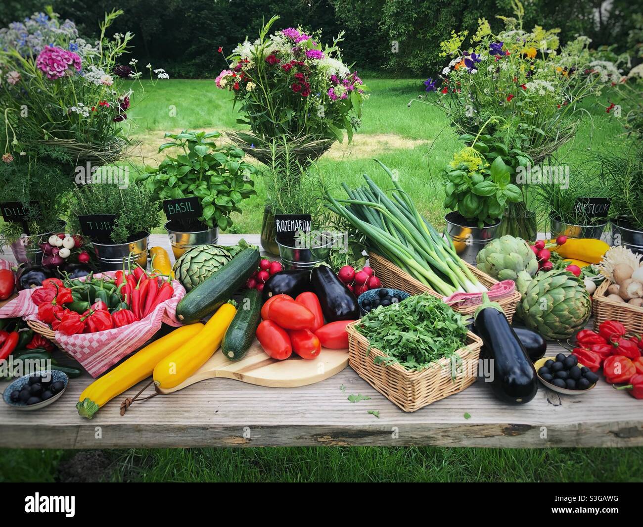 Verdure fresche e fiori su un tavolo di legno - Immagine stock catturata con smartphone