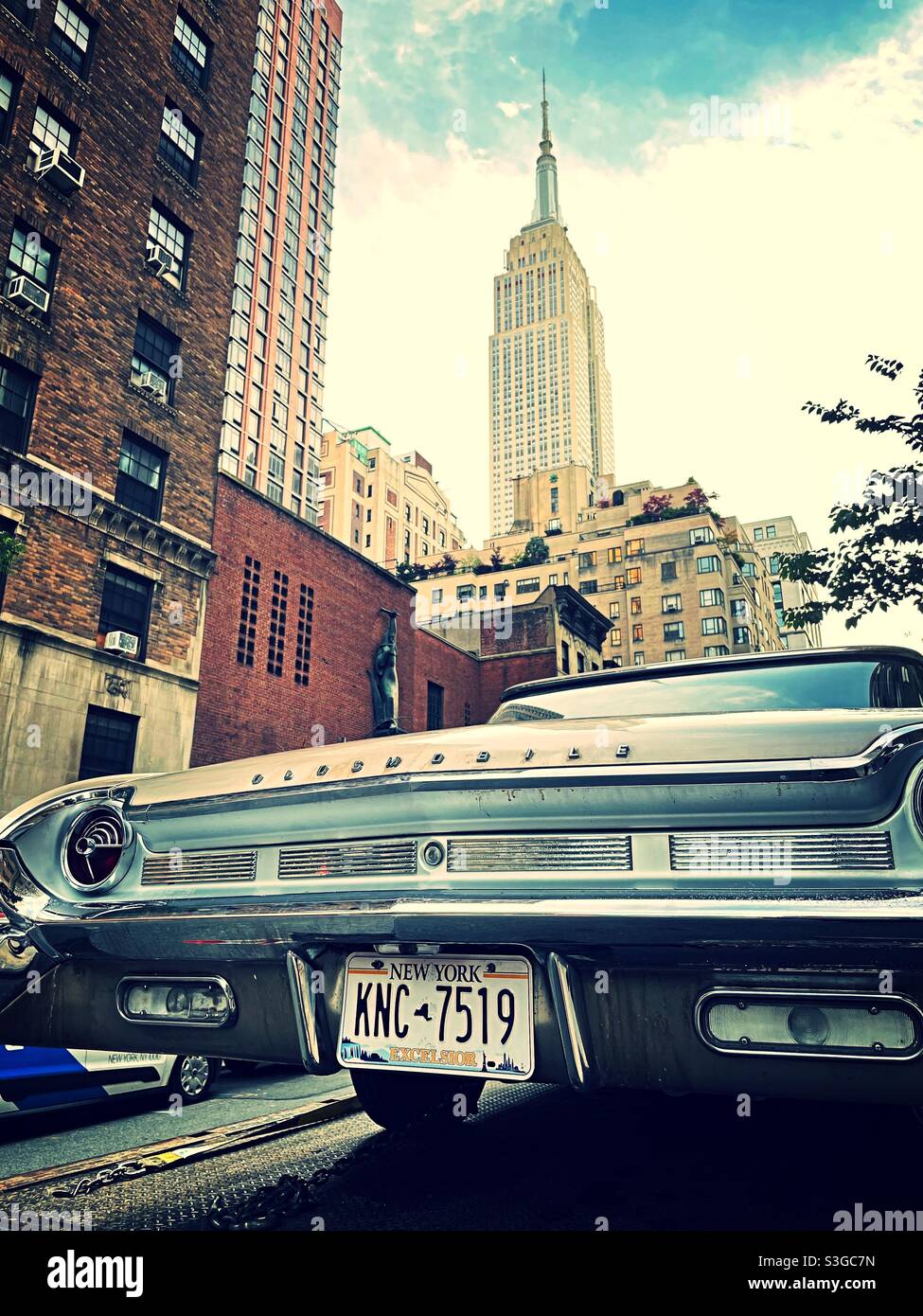 Un'automobile Oldsmobile d'epoca è parcheggiata nel quartiere di Murray Hill, nella città di New York, vicino all'Empire state Building, USA - Immagine stock catturata con smartphone