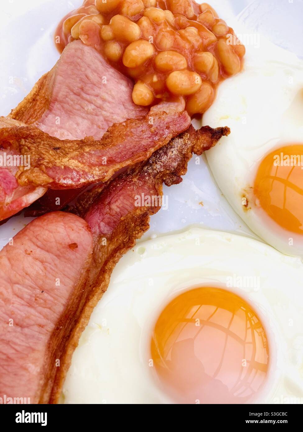 Colazione con uova fritte, fagioli al forno e pancetta Foto Stock