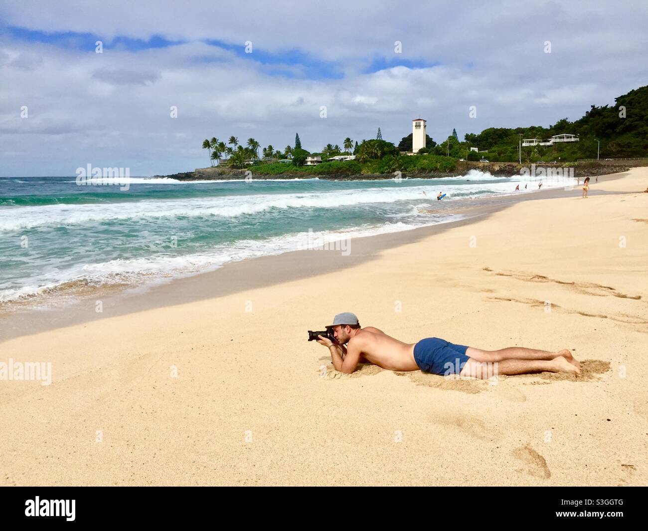 Uomo che scatta foto sulla spiaggia, baia di Waimea, Oahu, hawaii, USA Foto Stock