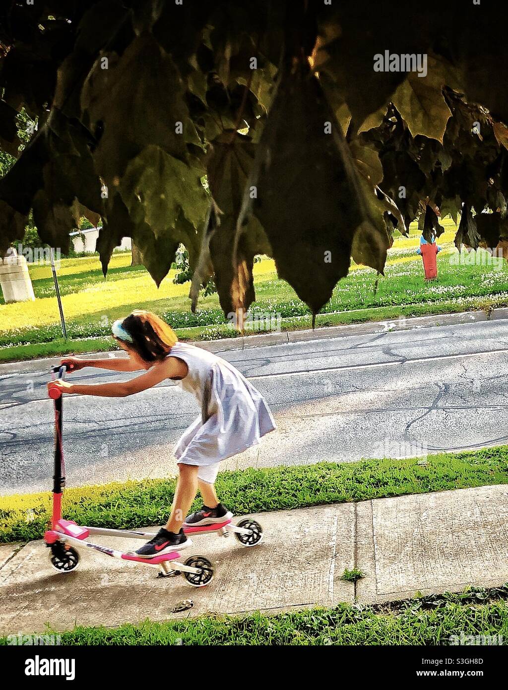 Bambina che guida uno scooter - il momento decisivo Foto Stock