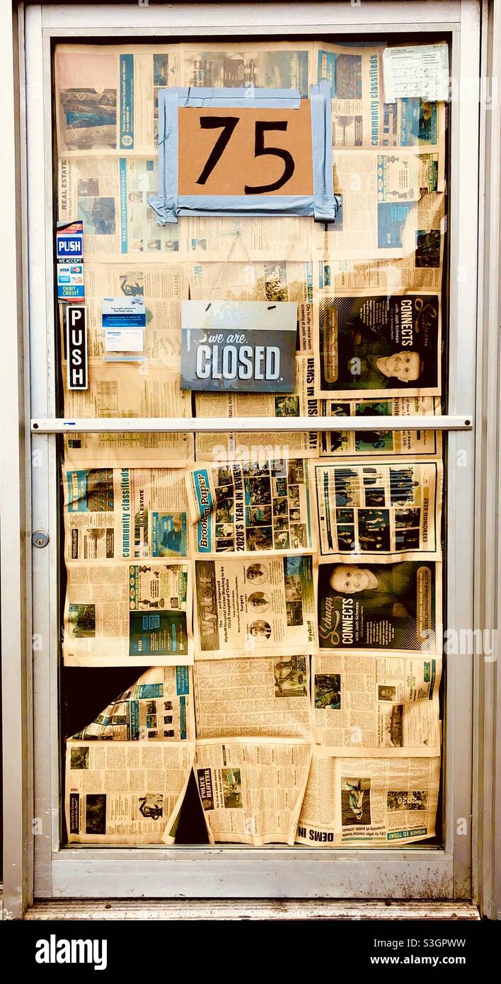Il negozio è chiuso a causa di una pandemia con ingresso coperto da giornali. - Immagine stock catturata con smartphone