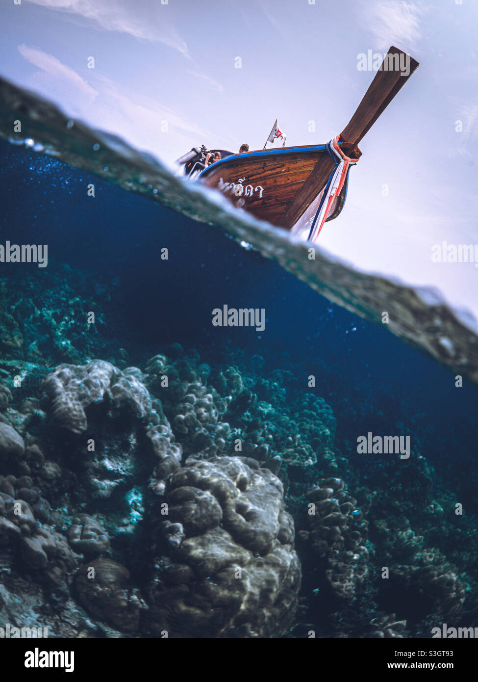 Lunga coda di legno barca tipic fromThailandia andare a snorkeling in acque blu e limpide Foto Stock