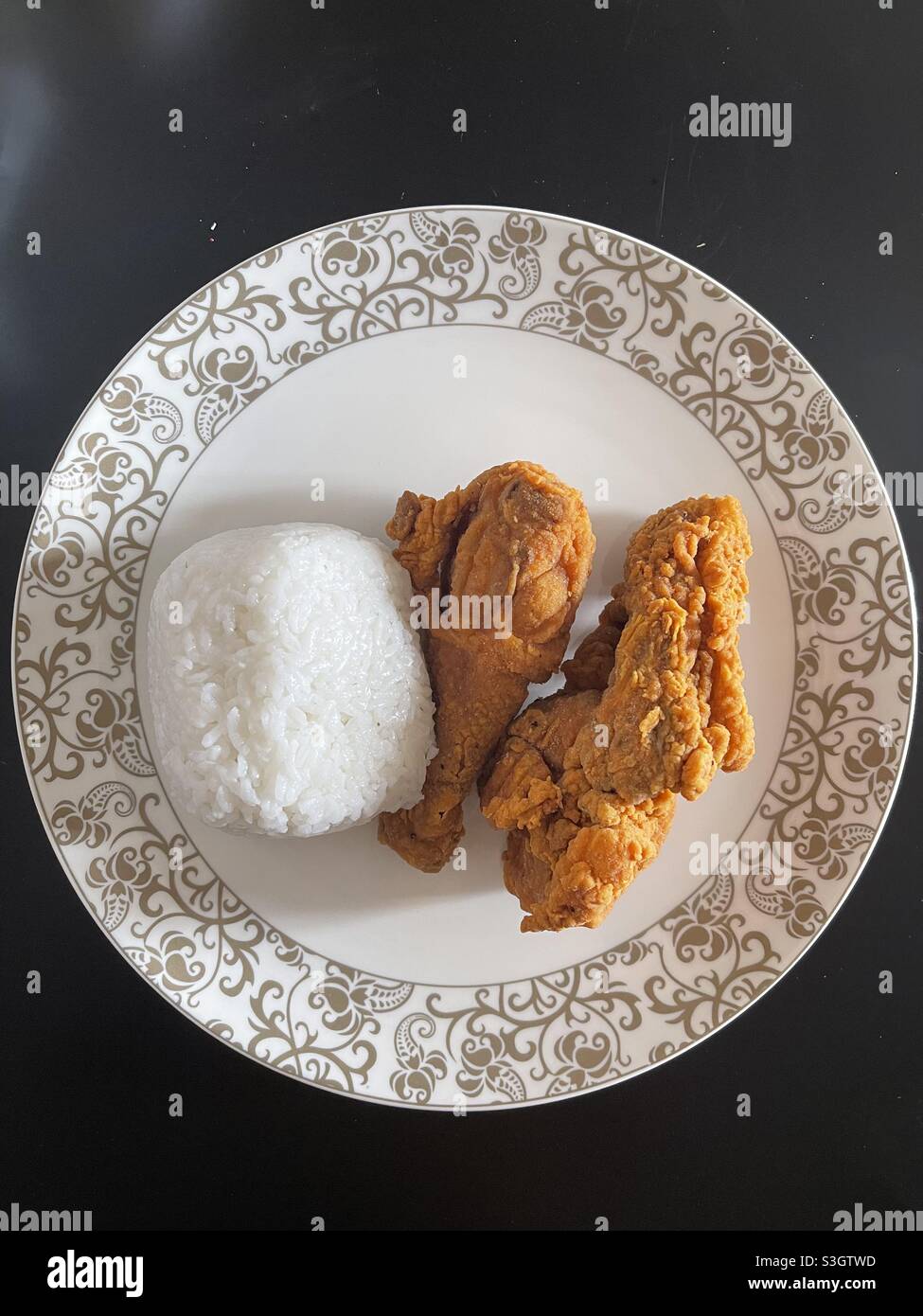 due pezzi di pollo fritto e una tazza di riso Foto Stock