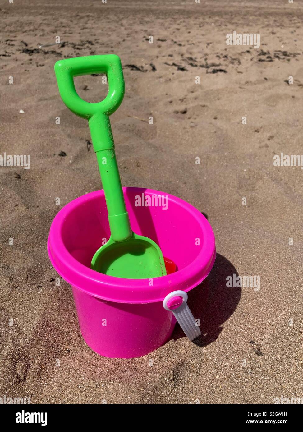 Secchio e vanga - vanga verde- secchio rosa- secchio mare e vanga- secchio giocattolo per bambini e vanga- mare per bambini - spiaggia- spiaggia di sabbia- sandbox Foto Stock