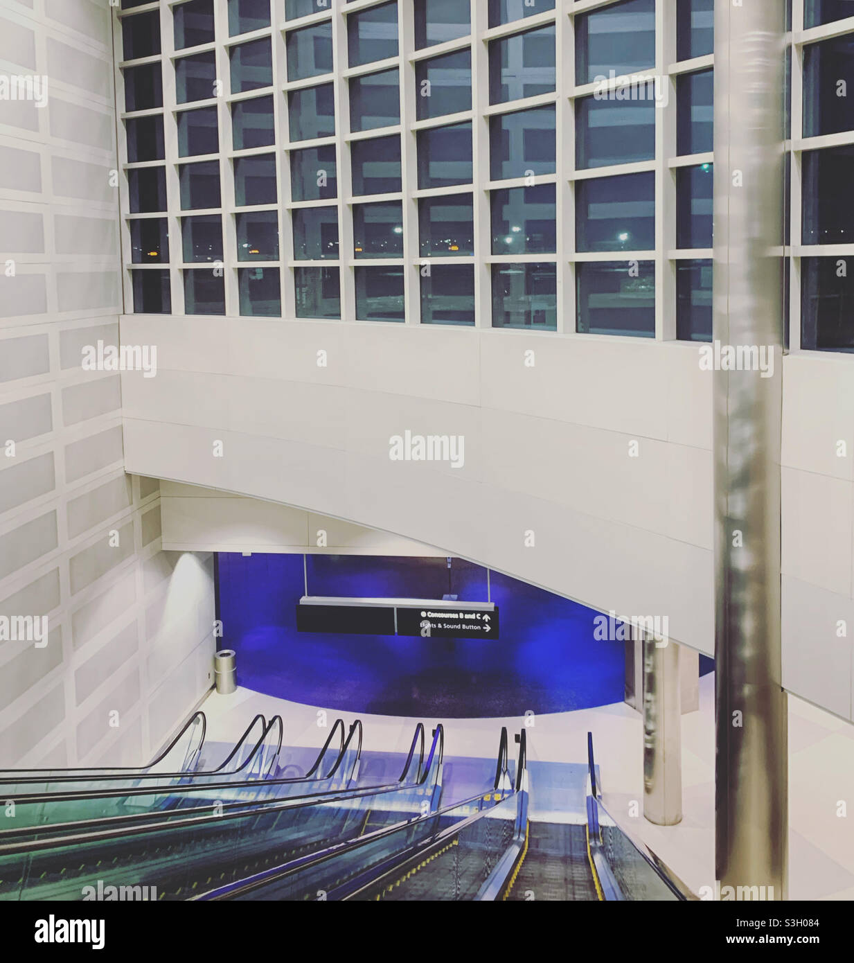 Scendendo una scala mobile verso il tunnel LED, il terminal McNamara, l'aeroporto metropolitano di Detroit Wayne County, Romulus, Michigan, Stati Uniti - Immagine stock catturata con smartphone