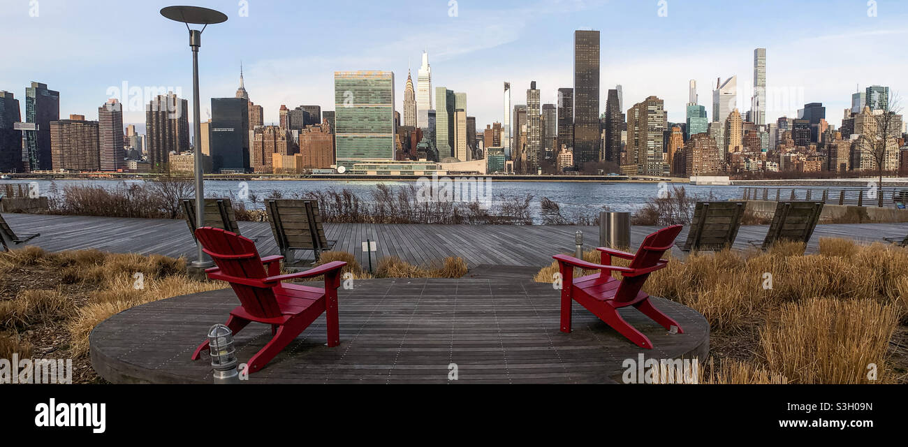 Sedie rosse per sedersi con vista sul centro di Manhattan Foto Stock