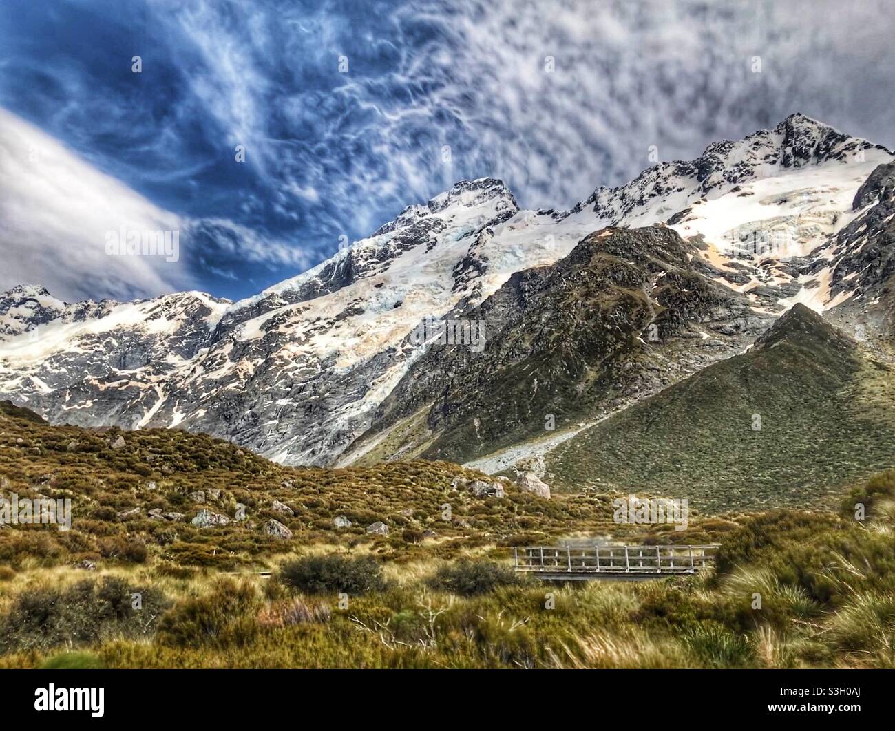 Ponte pedonale sul Hooker Valley Track nel Parco Nazionale Aoraki Mount Cook con spettacolari paesaggi sullo sfondo, regione di Canterbury, South Island, Nuova Zelanda Foto Stock