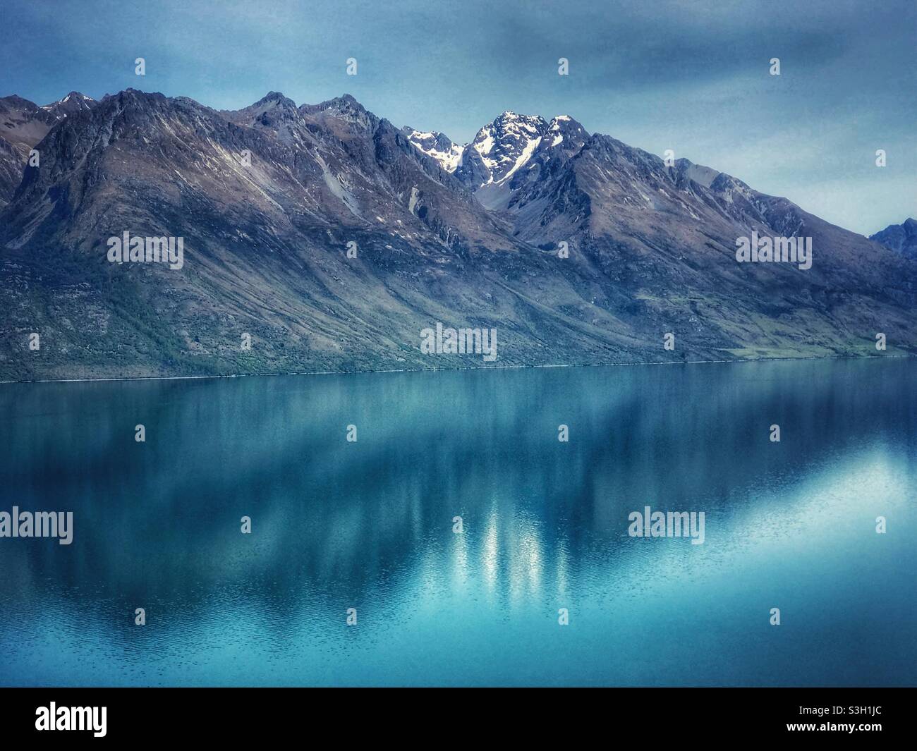 Montagne riflesse nel lago Wakatipu vicino Queenstown, regione di Otago, Isola del Sud, Nuova Zelanda - Immagine stock catturata con smartphone