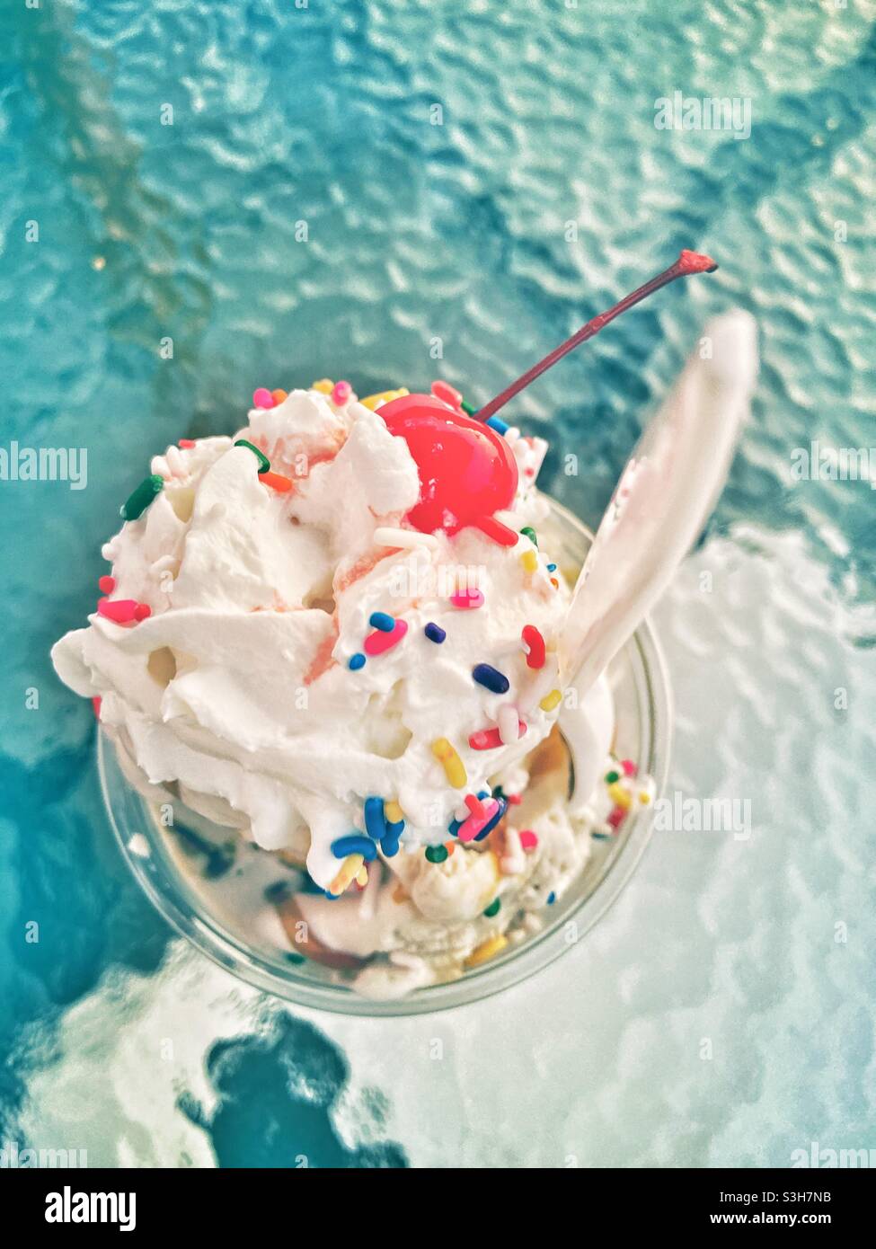 Gelato con crema montata spruzzata colorata e una ciliegia sulla parte superiore vista dall'alto. Estate giorno divertimento trattare vacanza concetto di vacanza. - Immagine stock catturata con smartphone