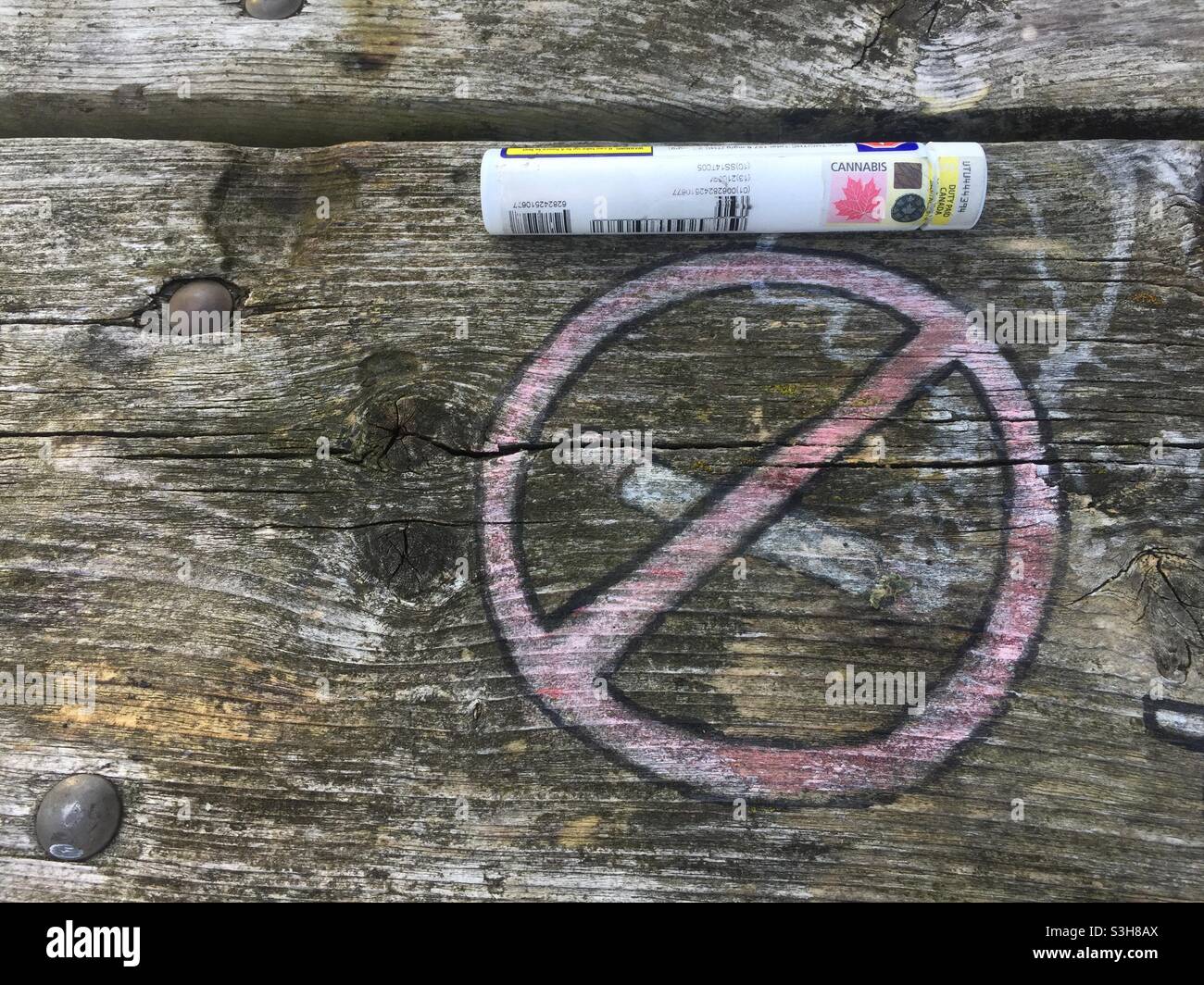 Una fiala di cannabis accanto al simbolo di divieto di fumo. Suggerimento, forse non intenzionale, fumare le cose giuste - erbacce, CBD, smussate - non sigarette di tabacco cancerogene. Foto Stock