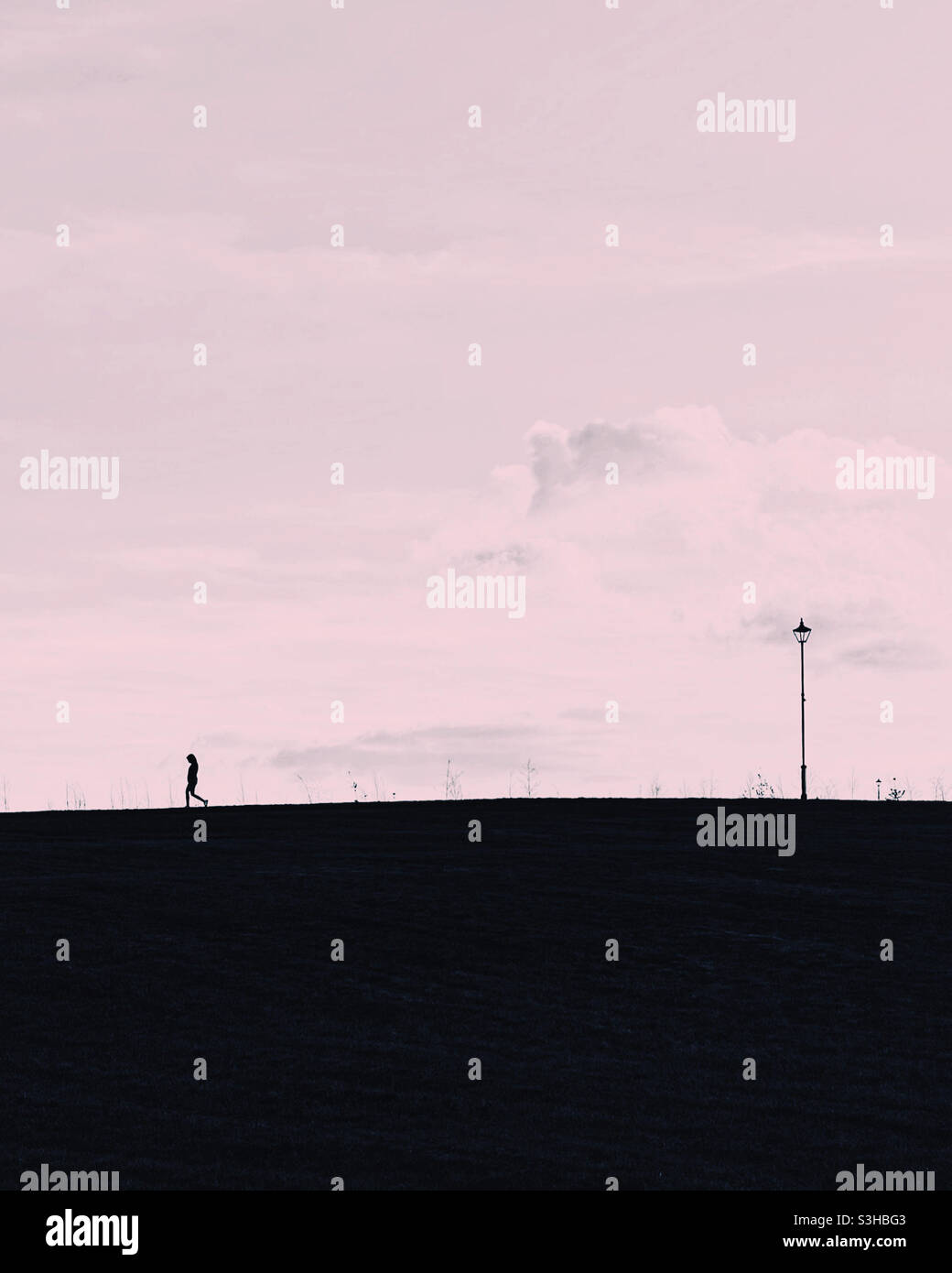 Silhouette in collina con lampione. Foto Stock
